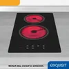 A close-up, slightly angled view of a black electric stovetop with two red-hot heating elements, set into a light gray countertop. Produktbild-Vorschau