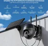 A security camera with a solar panel mounted on a wall under a blue sky with clouds. Produktbild-Vorschau