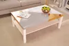 A modern coffee table with a geometric design, featuring marble, gray, and gold sections, placed in a living room setting next to a sofa. Podgląd zdjęcia produktu