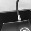 A close-up view of a black kitchen sink with a flexible faucet hose extending into it. Náhľad obrázku produktu