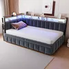 A modern daybed with integrated LED lighting and storage shelves, set in a bedroom. Produktbild-Vorschau