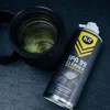 A camera lens and a can of cleaning spray are placed on a dark gray surface. Podgląd zdjęcia produktu