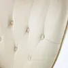 A close-up view of the tufted upholstery of a beige armchair. Náhled obrázku produktu