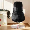 A black Christmas tree storage bag is shown on a stand with a white tree skirt in a room with a fireplace and Christmas decorations. Produktbild-Vorschau