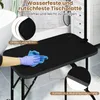 A hand wearing a blue glove is cleaning a black grooming table with a blue cloth. The table has a textured surface and rounded corners. There are also text overlays highlighting features. Anteprima dell’immagine prodotto