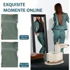 A woman is shown in a mirror wearing a green suit, with a handheld steamer and folded clothes in the foreground. Two close-up shots of a green garment are shown on the left, labeled 'before hanging' and 'after hanging'. Produktbild-Vorschau