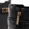 Close-up of a black boot with a gold zipper and buckle. Voir les images du produit