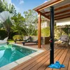 An outdoor shower next to a swimming pool and lounge chairs. Náhľad obrázku produktu