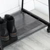 A close-up view of a black metal garment rack with a gray fabric shelf, holding two black boots. Náhľad obrázku produktu