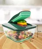 A vegetable chopper with a clear bowl filled with chopped vegetables, placed on a wooden surface. Anteprima dell’immagine prodotto