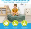 A young boy is playing with building blocks on a folded green mattress in a child's room. Produktbild-Vorschau