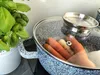 A pot with carrots inside, next to a basil plant. Produktbild-Vorschau