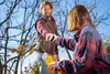 A man and a woman are in a garden, with the man handing a battery to the woman who is holding a gardening tool. Produktbild-Vorschau
