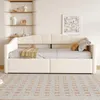A beige daybed with storage drawers is shown in a room with shelves and a rug. Produktbild-Vorschau