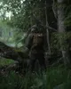A person wearing a backpack stands in a forest. Produktbild-Vorschau