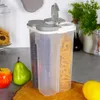 A multi-compartment food storage container filled with dry goods, placed on a countertop with some fruit in the foreground. Náhľad obrázku produktu