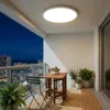 A balcony at night with a table, chairs, and plants, illuminated by a ceiling light. Produktbild-Vorschau