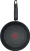 A top-down view of a black frying pan with a red indicator in the center and a black handle. Voir les images du produit