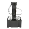 A black automatic ping pong ball machine sits in a box filled with white ping pong balls, against a white background. Podgląd zdjęcia produktu