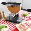 A raclette grill with a half wheel of cheese is set up on a table with a red and white checkered tablecloth, set for a meal with wine, salad, and charcuterie. Produktbild-Vorschau
