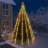 A decorated Christmas tree with colorful lights and ornaments stands in the snow next to a house. Náhled obrázku produktu