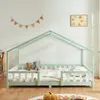 A child's bed with a house frame, set up in a room with toys. Produktbild-Vorschau