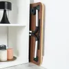 A folded laptop table is leaning against a white wall next to a white shelf unit. Produktbild-Vorschau