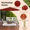 A patio umbrella set up over a table and chairs on a wooden deck. Anteprima dell’immagine prodotto