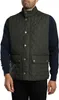 A man wearing a green quilted vest over a navy sweater. Produktbild-Vorschau