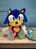 A plush toy of Sonic the Hedgehog sitting on a wooden surface. Produktbild-Vorschau