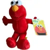 A plush toy of Elmo from Sesame Street is shown against a white background, holding a tag. Produktbild-Vorschau