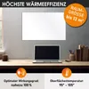 A white infrared heating panel is mounted on a wall above a desk with a laptop, a cup, and books. Produktbild-Vorschau