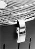 A close-up view of a charcoal grill's latch mechanism and grate. Náhled obrázku produktu