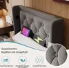 A close-up view of a gray upholstered headboard with tufted buttons, featuring two electronic devices (a tablet and a phone) resting on a pillow in front of it. The image also includes marketing text and icons at the bottom. Náhled obrázku produktu