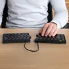 A person's hands are typing on a split ergonomic keyboard. Produktbild-Vorschau