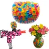 A collection of colorful gel beads in a bowl, a gel bead gun, and a vase of flowers with gel beads. Náhled obrázku produktu