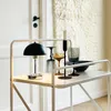 A table lamp and decorative items are displayed on a white serving cart. Produktbild-Vorschau