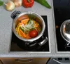 A pot of vegetables is on a stovetop. Anteprima dell’immagine prodotto
