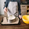 A person is shown in a kitchen preparing a cake, using a cake ring and spatula. A yellow bowl is also visible. Podgląd zdjęcia produktu