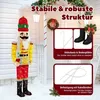 A large illuminated nutcracker figure stands on a snowy porch decorated for Christmas. Produktbild-Vorschau