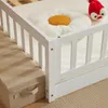 Close-up view of a white wooden children's bed with a daisy-shaped pillow and a red stuffed toy. Náhľad obrázku produktu