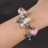 A close-up shot of a charm bracelet on a person's wrist. Náhled obrázku produktu