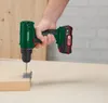 A person is using a cordless drill to screw a metal bracket onto a wooden surface. Produktbild-Vorschau