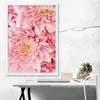 A framed poster of pink flowers hangs on a textured white wall above a desk with a laptop and a small potted plant. Produktbild-Vorschau