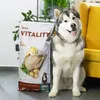 A large bag of dog food stands next to a husky dog, with a yellow chair in the background. Náhled obrázku produktu