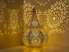 A decorative lantern casting intricate shadows on a wall. Produktbild-Vorschau
