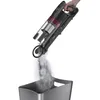 A hand is holding a cordless vacuum cleaner and emptying dust into a bin. Voir les images du produit