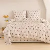 A neatly made bed with a floral patterned duvet and pillows. Produktbild-Vorschau