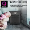 A person holding a baby next to an air fryer. Produktbild-Vorschau