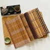 A collection of bamboo placemats and small bowls arranged on a white surface. Produktbild-Vorschau
